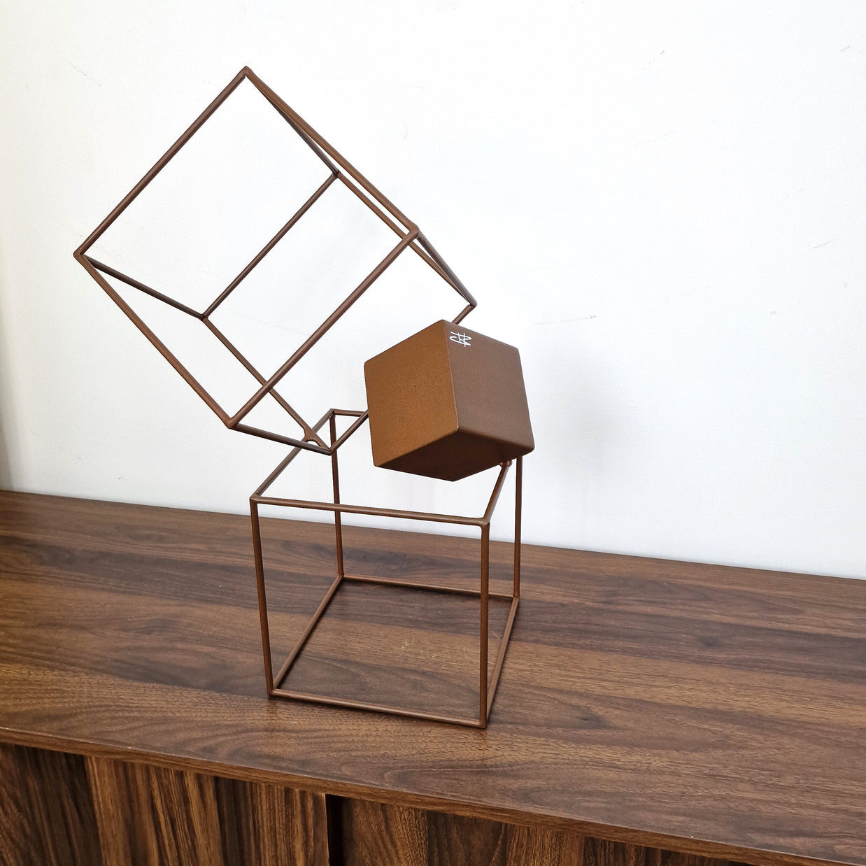 Escultura artística en acero con cubos suspendidos, diseño abstracto y minimalista.
