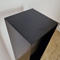 Base negra de diseño puro, perfecta para exhibir esculturas contemporáneas con estilo.