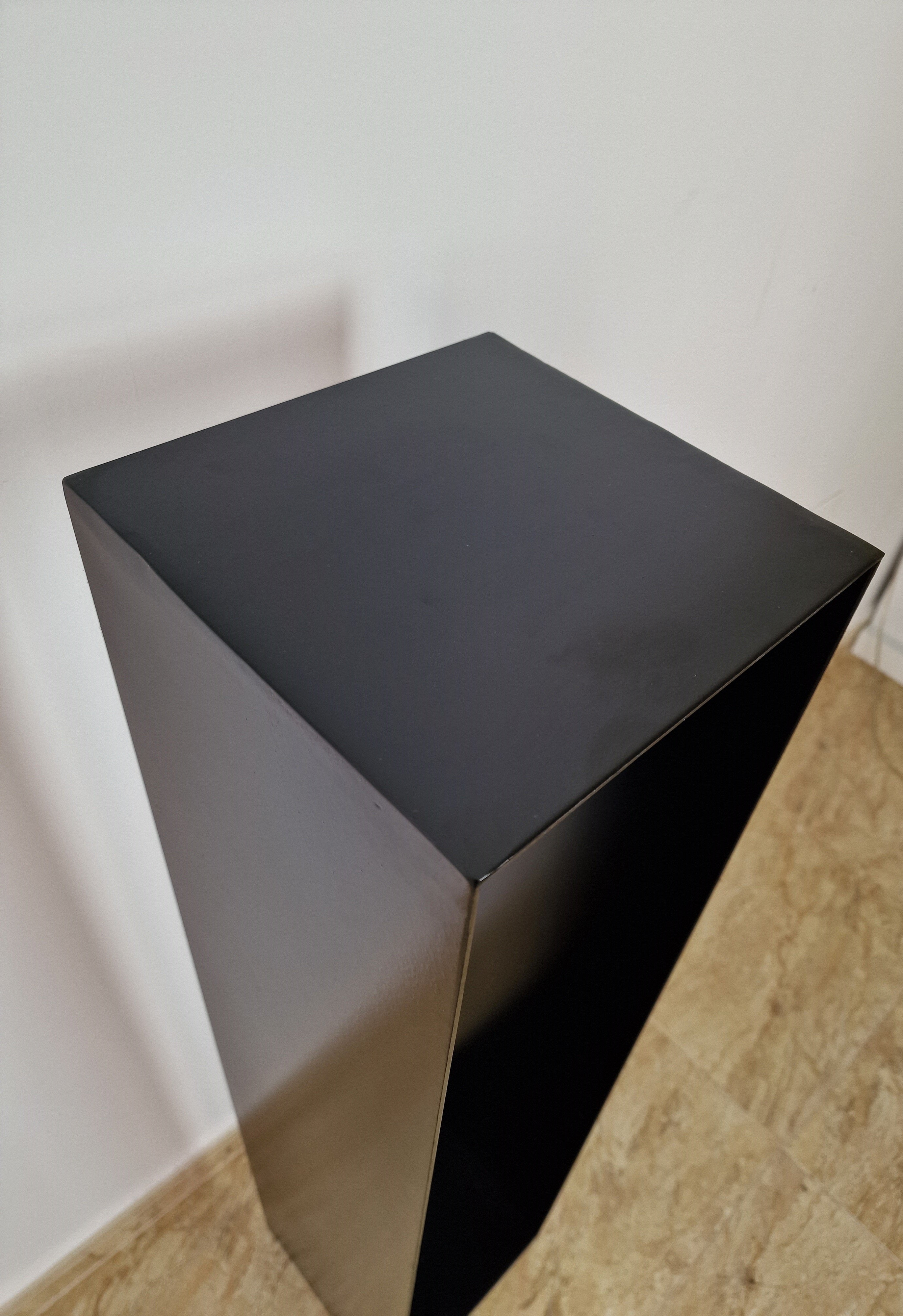 Base negra de diseño puro, perfecta para exhibir esculturas contemporáneas con estilo.
