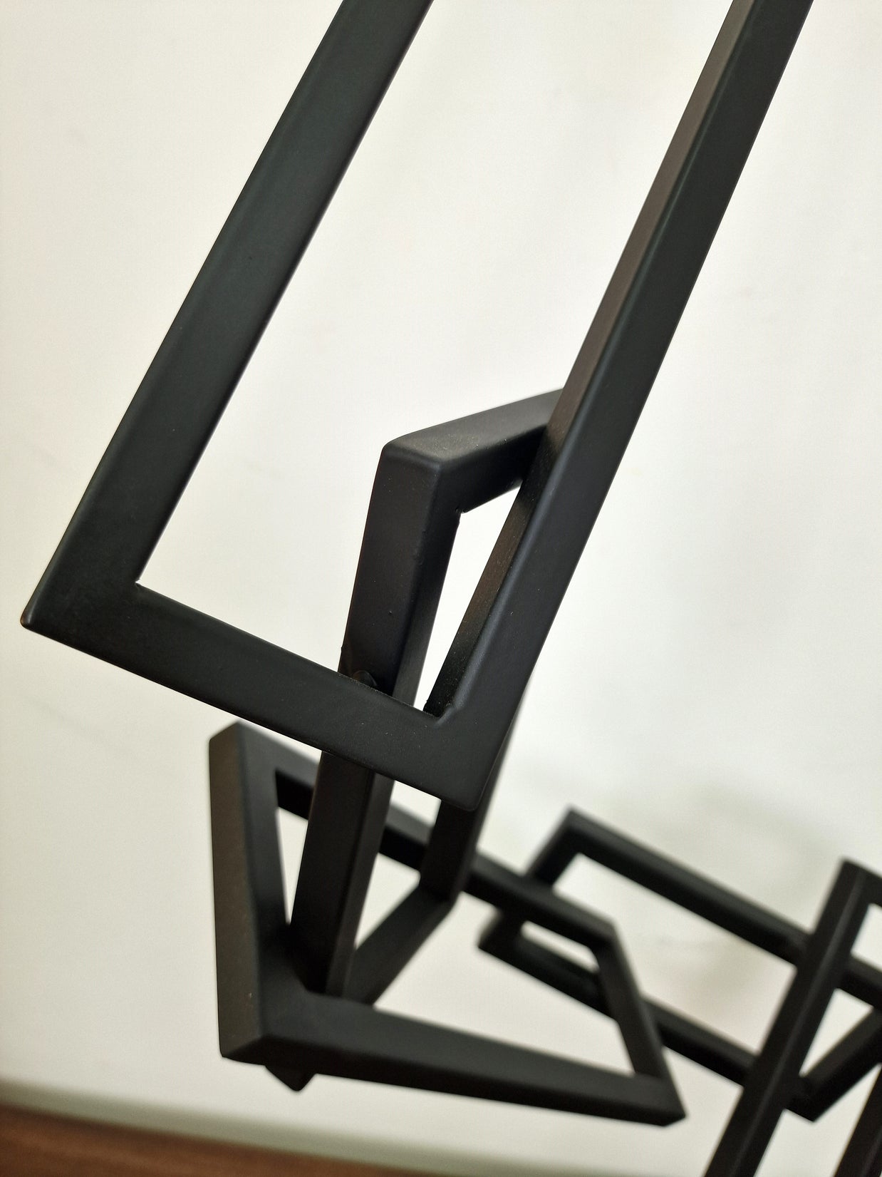 Escultura geométrica en hierro pintado, con líneas rectas ascendentes, ideal para salas de estar o despachos contemporáneos.