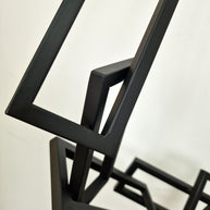 Escultura geométrica en hierro pintado, con líneas rectas ascendentes, ideal para salas de estar o despachos contemporáneos.