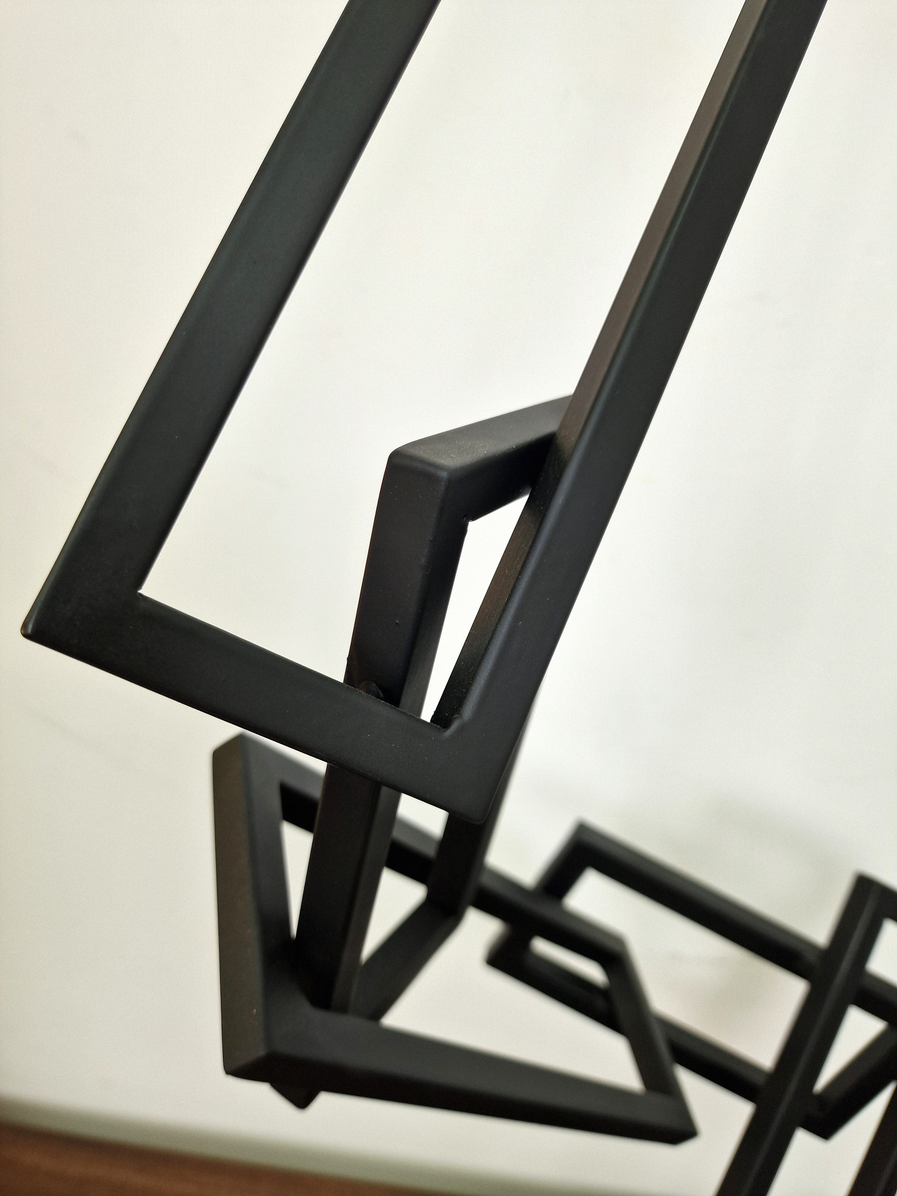 Escultura geométrica en hierro pintado, con líneas rectas ascendentes, ideal para salas de estar o despachos contemporáneos.