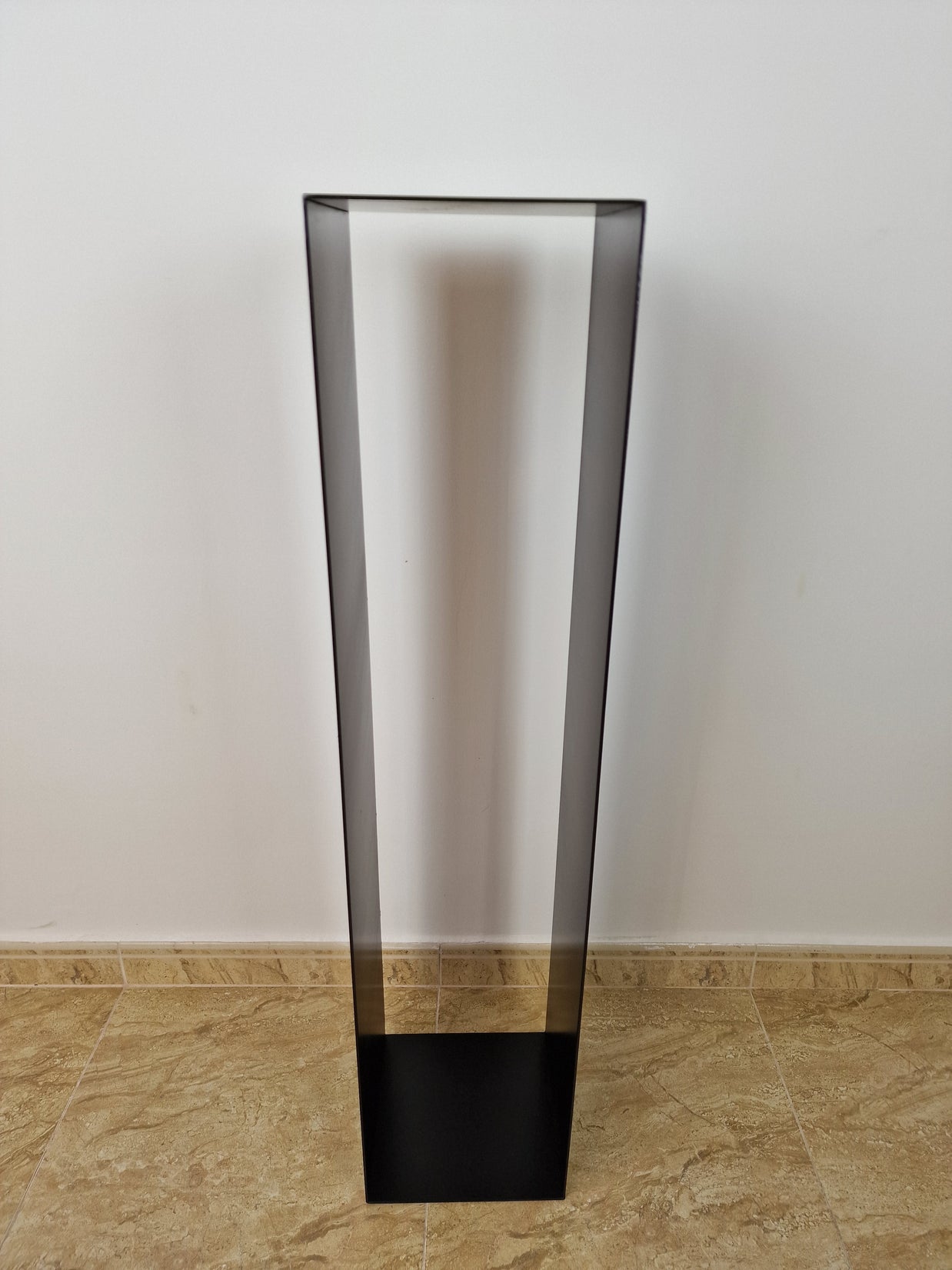 Peana negra de líneas limpias, ideal para resaltar esculturas en espacios modernos.