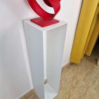 Pedestal sobrio y vertical, pensado para realzar piezas en entornos de galería contemporánea.