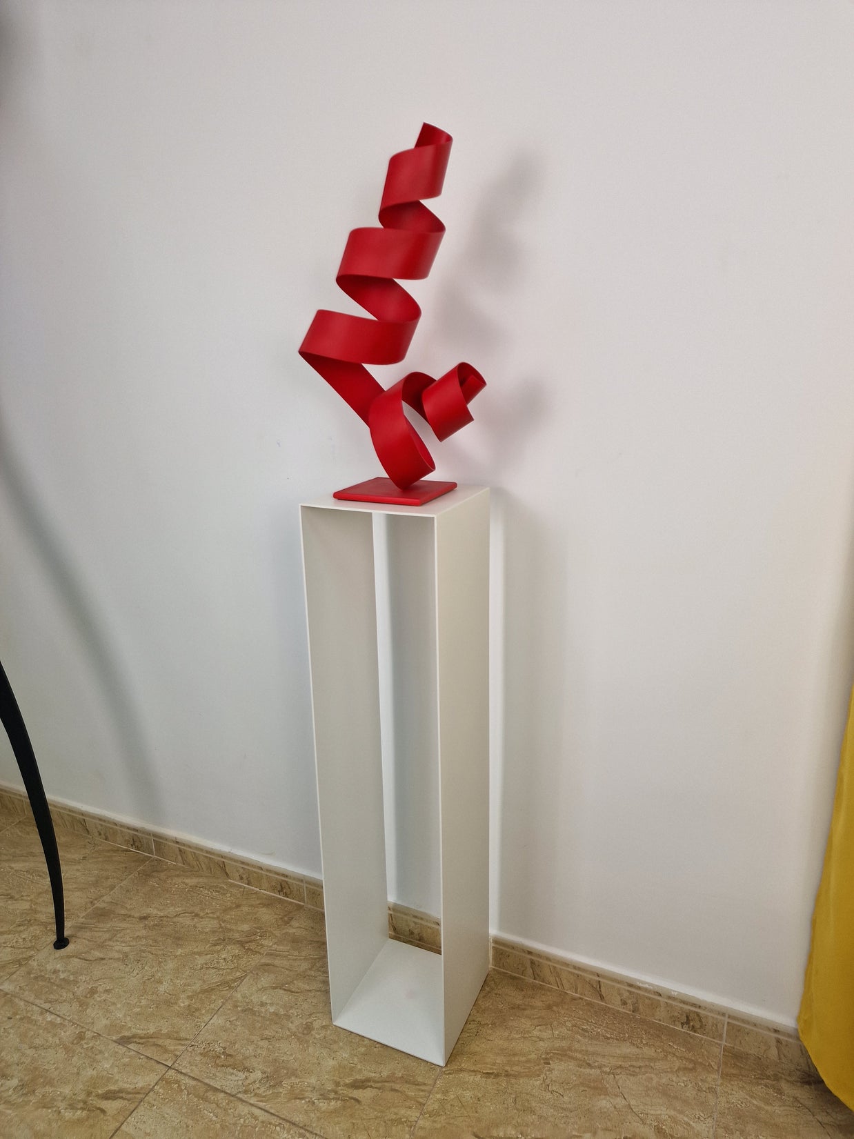 Pedestal de forma pura y vertical, pensado para complementar obras de arte en casa.