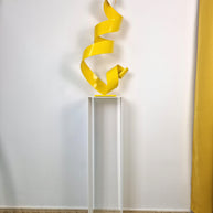 Soporte de forma pura que aporta altura y foco visual a esculturas en contexto de galería.