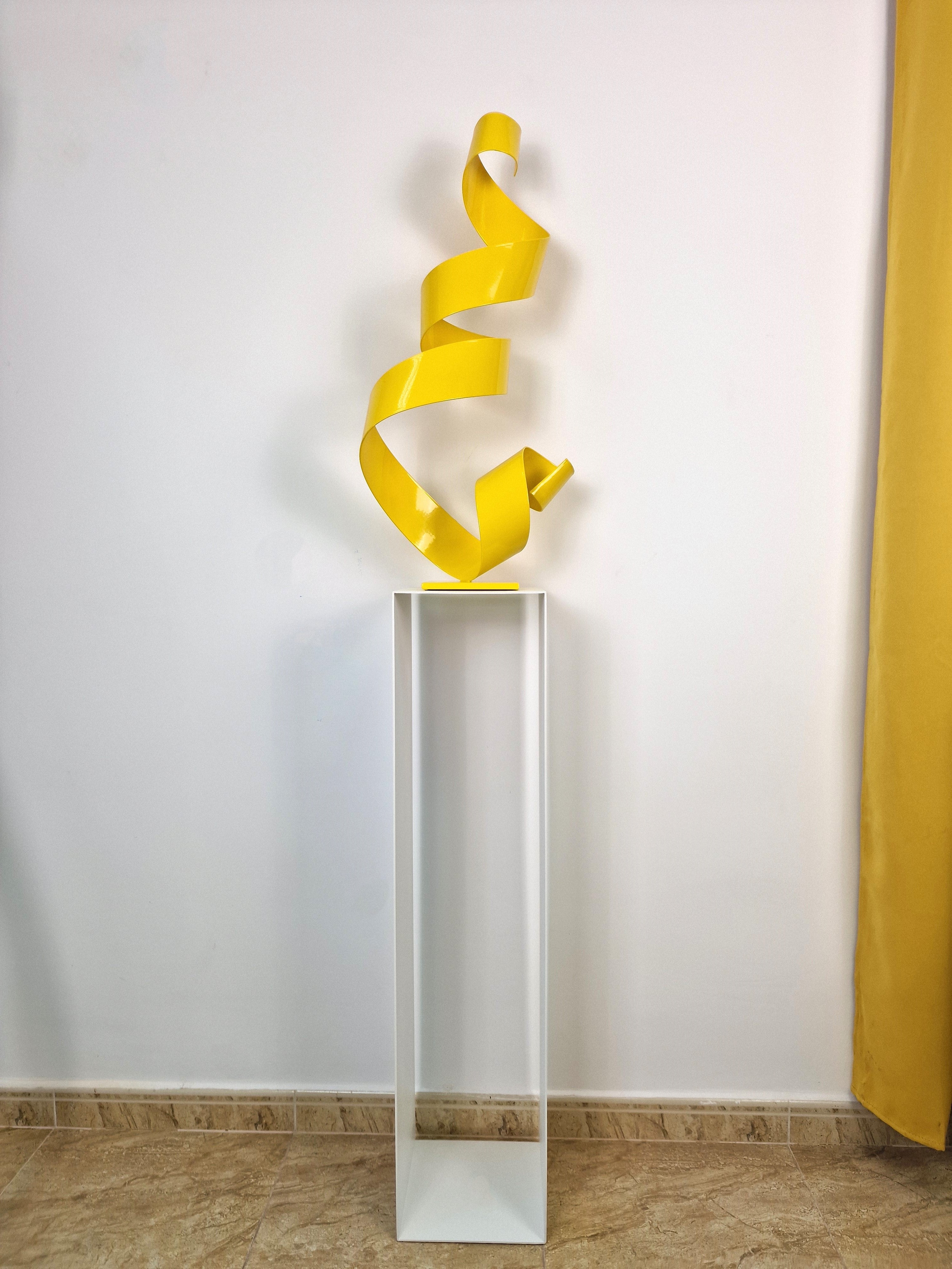 Soporte de forma pura que aporta altura y foco visual a esculturas en contexto de galería.